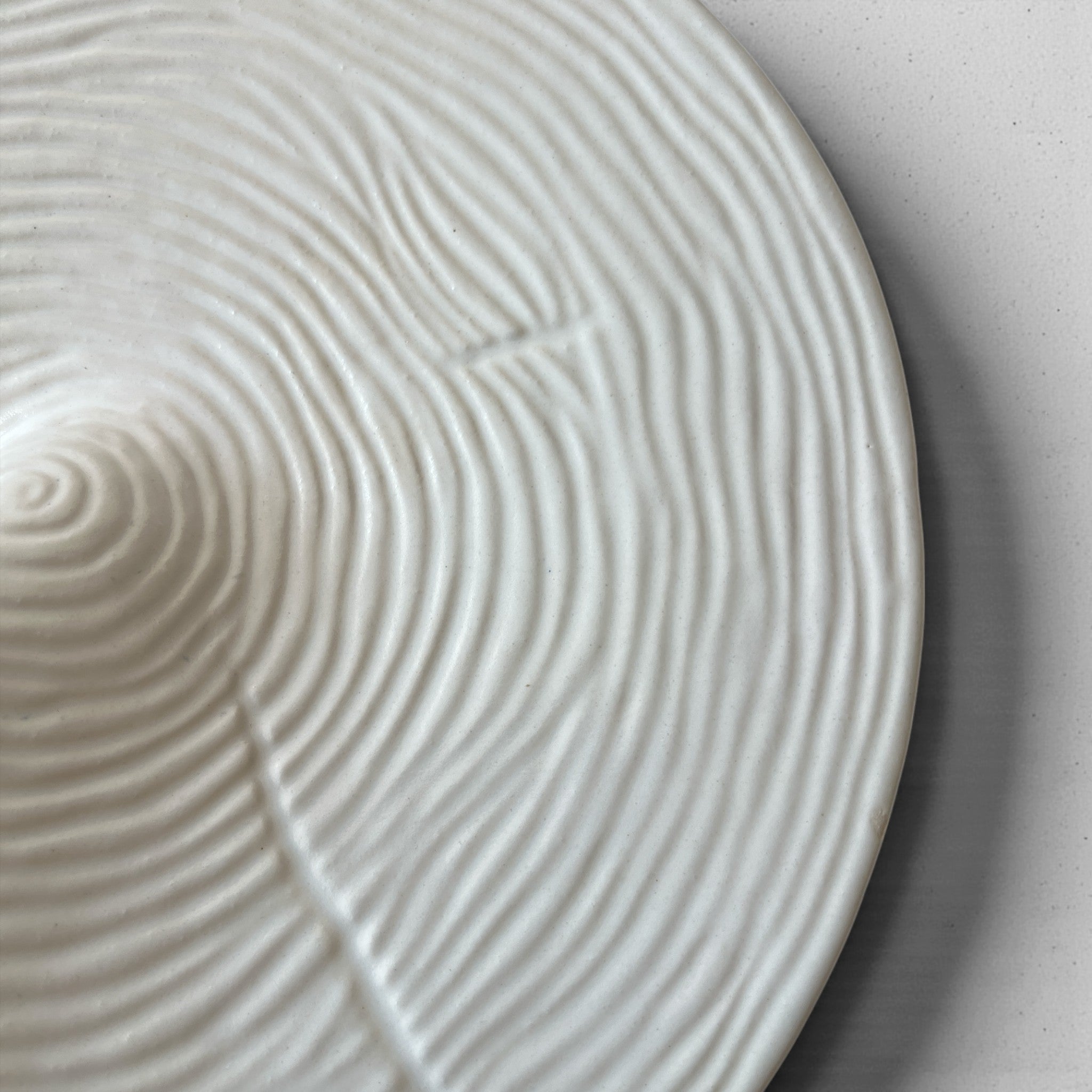 Close-up of the unique detail on a handcrafted arctic white ceramic plate