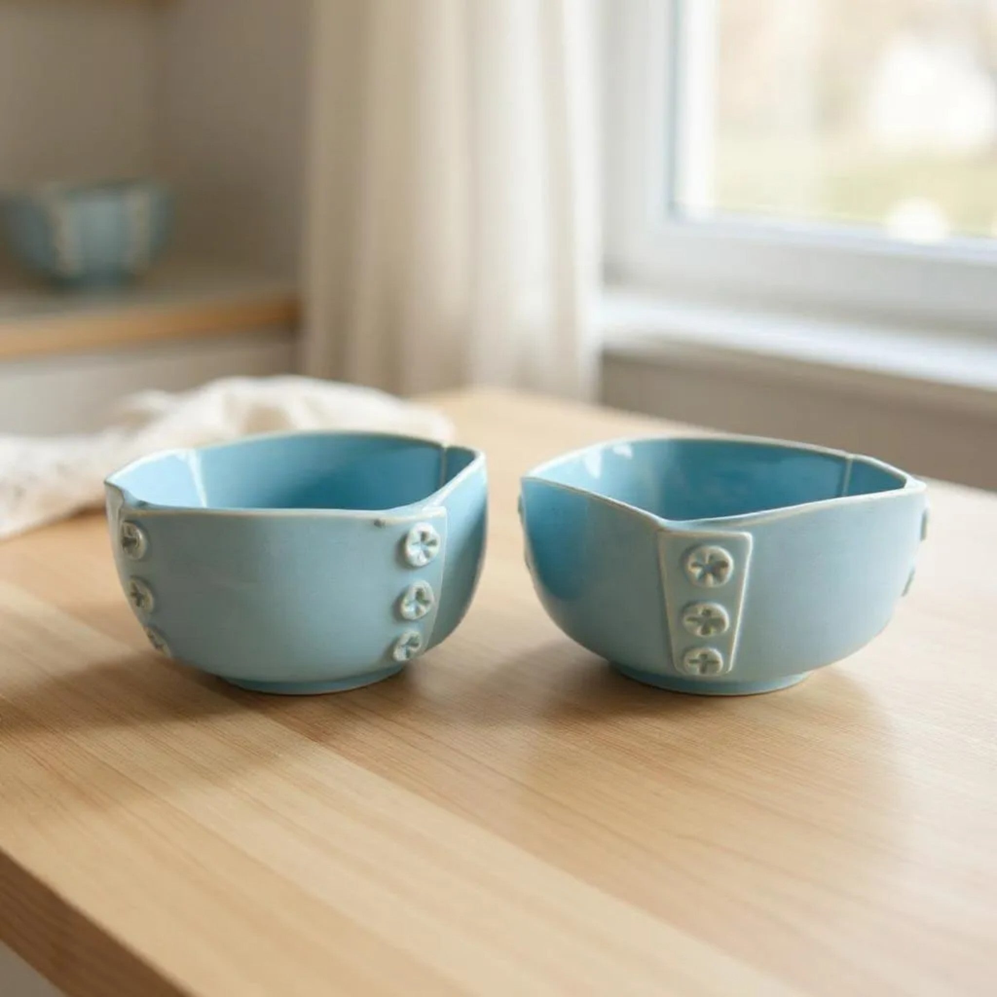 Two blue ceramic bowls with decorative elements on a wooden surface.