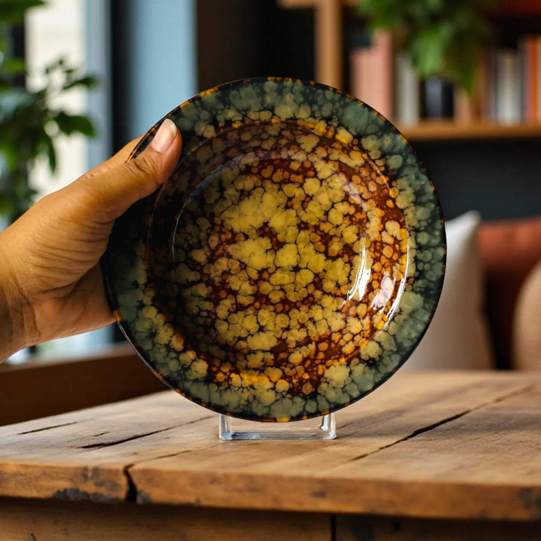 Hand holding the ceramic noodle plate to show the glaze and the scale reference.