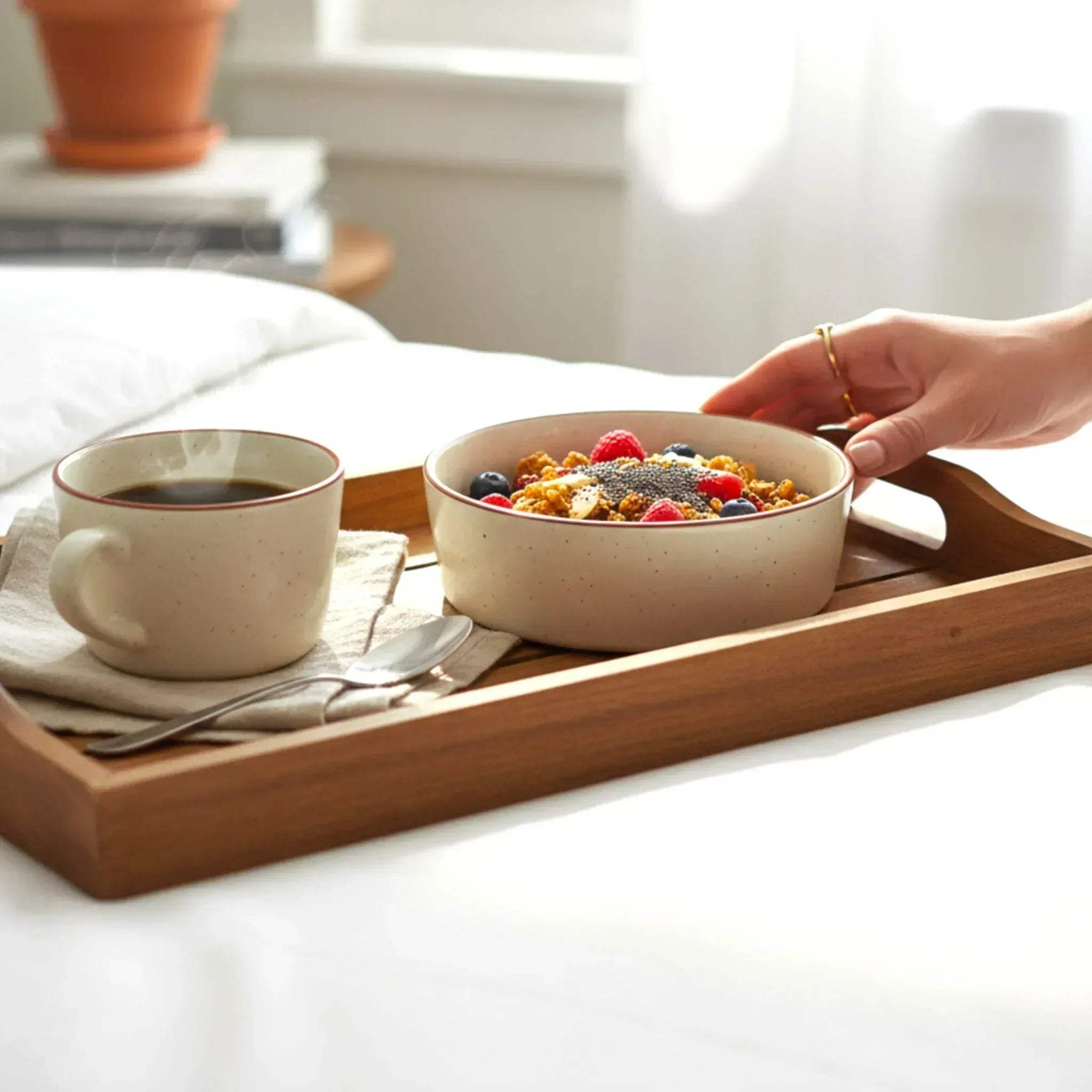 breakfast scene featuring an ivory ceramic bowl filled with cereal and fruit on a wooden tray