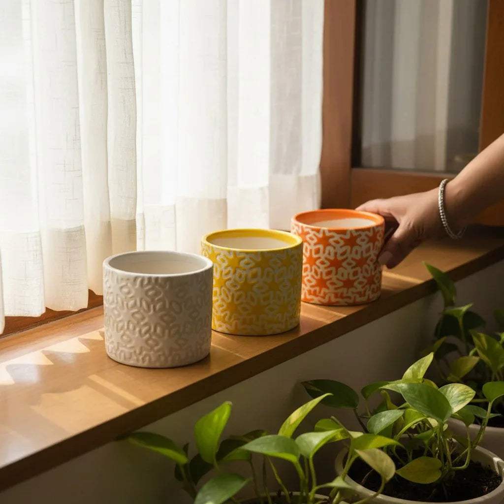 Citrus Squad Planters; set of 3 orange, yellow, and white geometric embossed ceramic balcony planters.