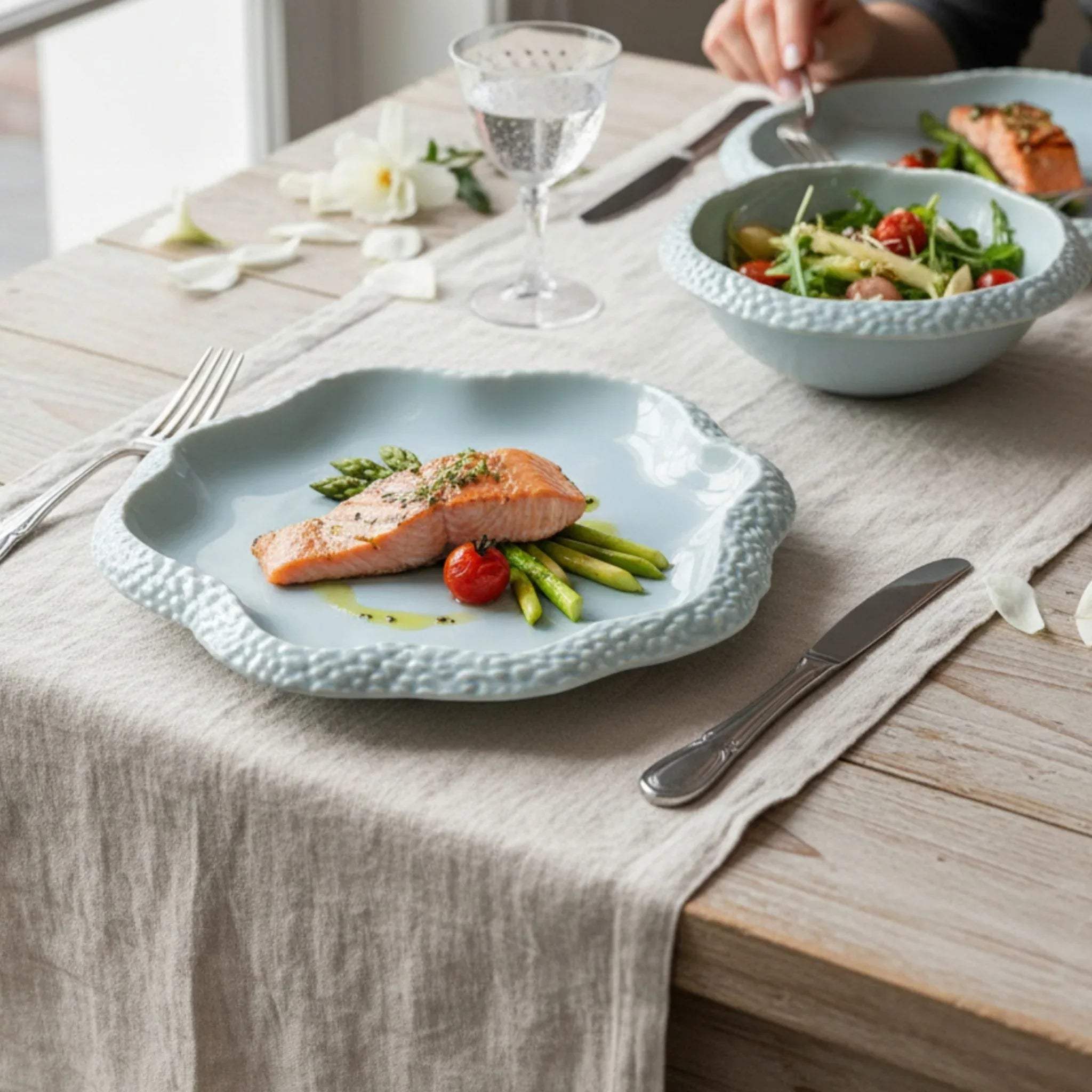 Coastal brunch setup; the seafoam plate served with a fresh garden salad and salmon and styled with linen napkins and steel cutlery.