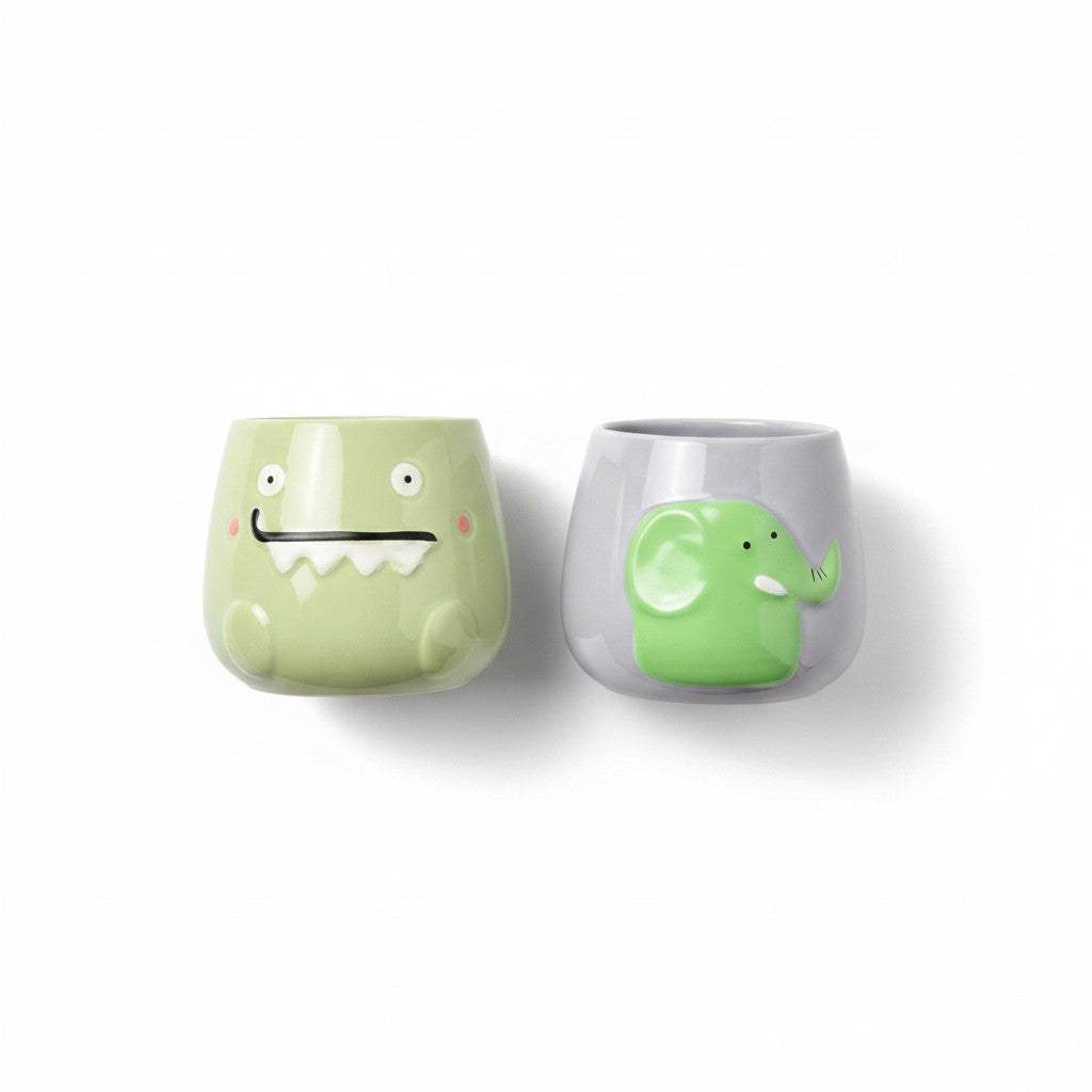 Close-up of the hand-painted details and smooth glossy glaze on the mint green monster ceramic pot.