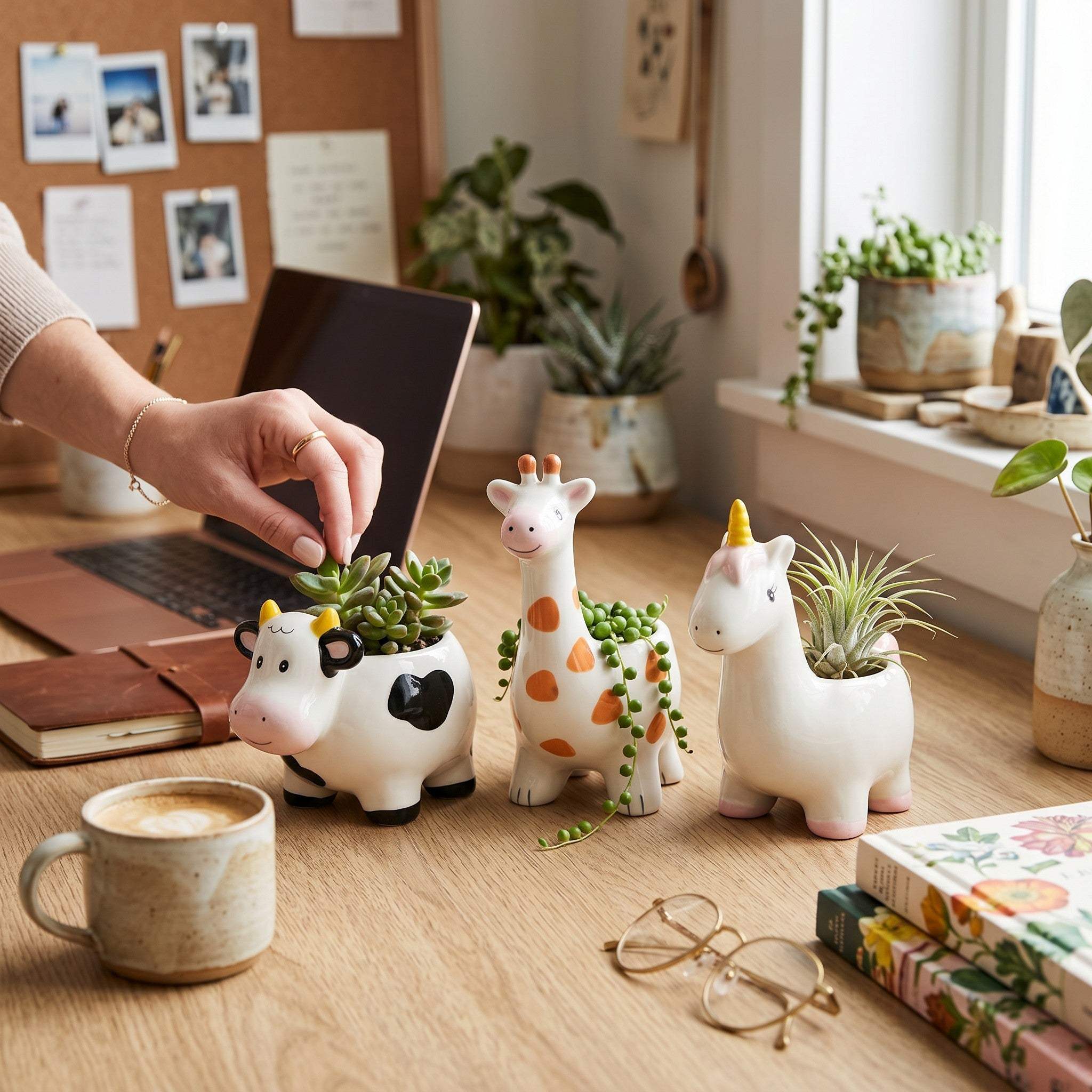 Creative workspace set up with decorative animal planters, a laptop, and a cup of coffee.