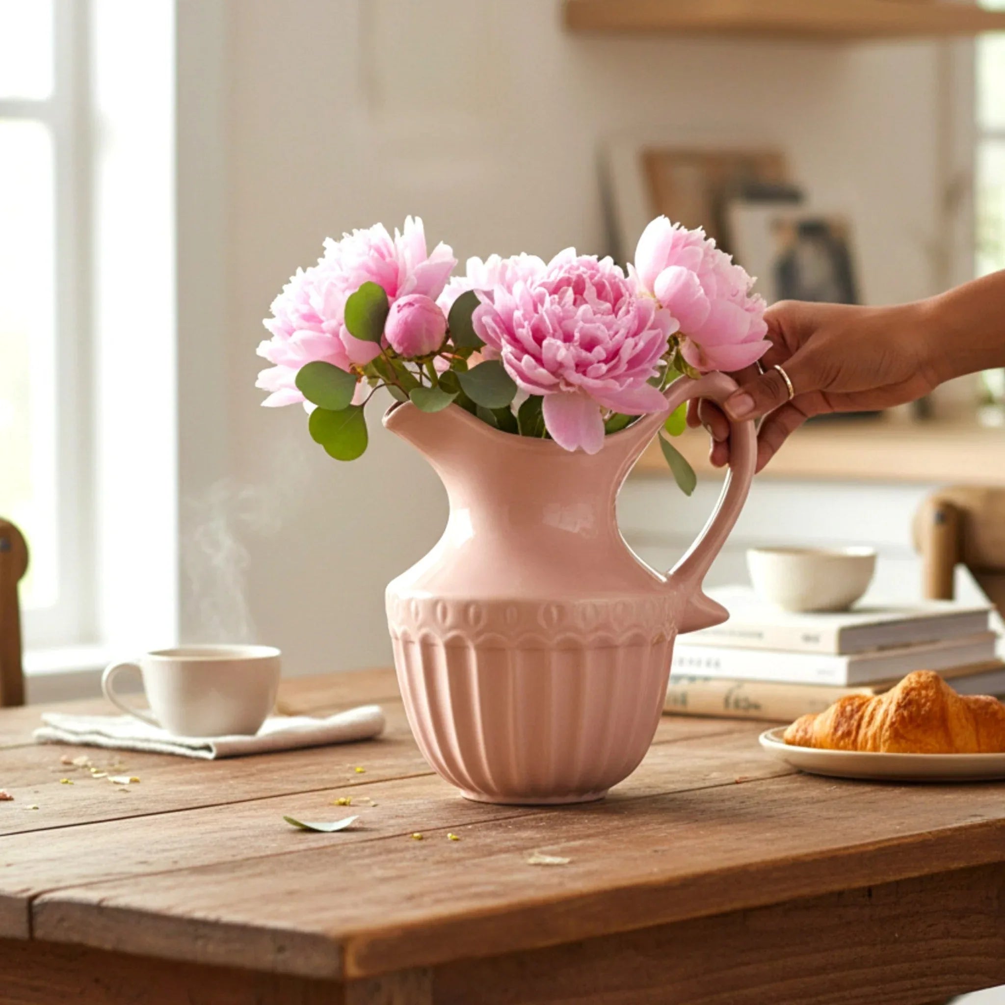 Decorative centerpiece; the Sky Mist pitcher used as a flower vase holding a bouquet of pink flowers.