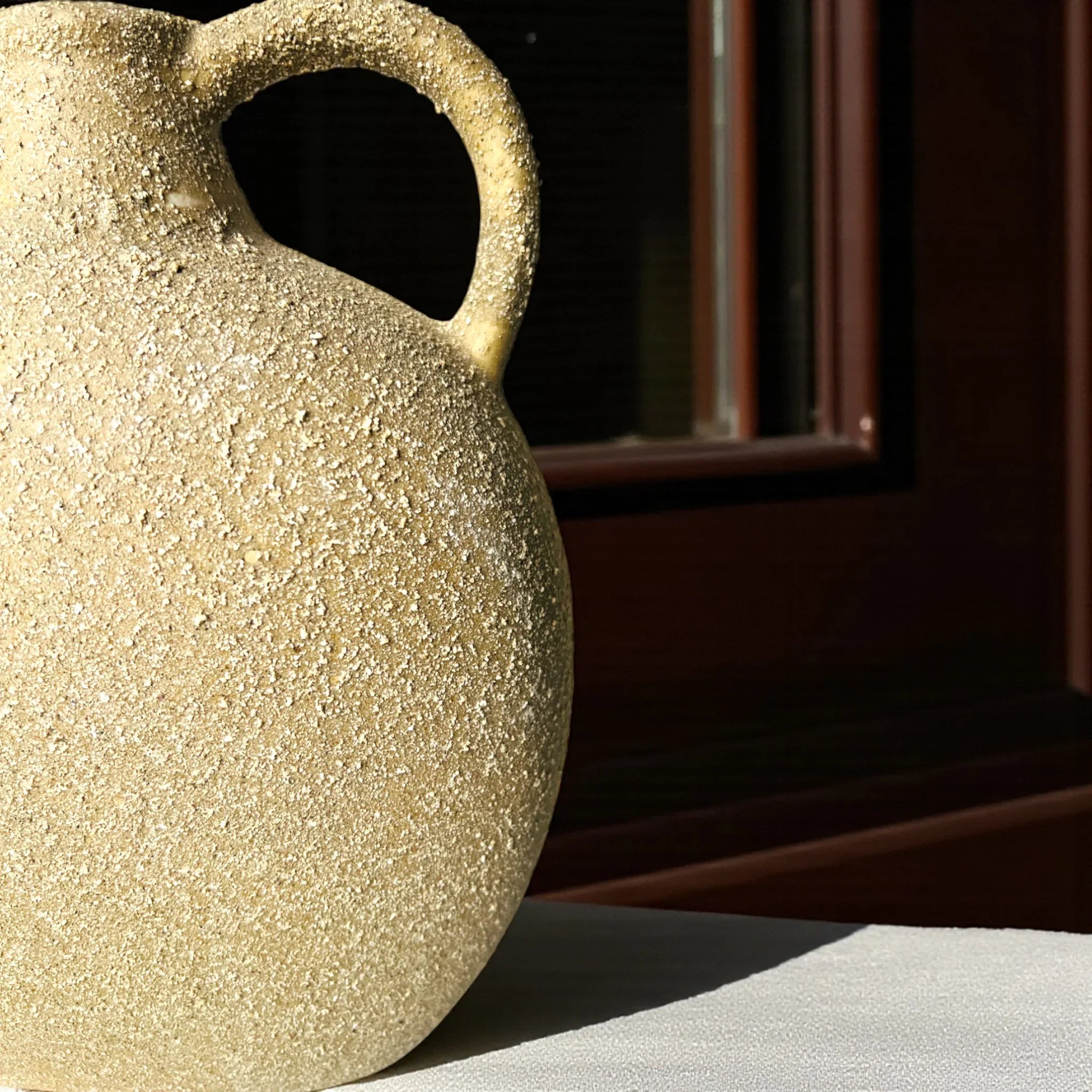 Grainy / sandy texture; matte tan pottery finish and artisanal ceramic craftsmanship for mood boards.