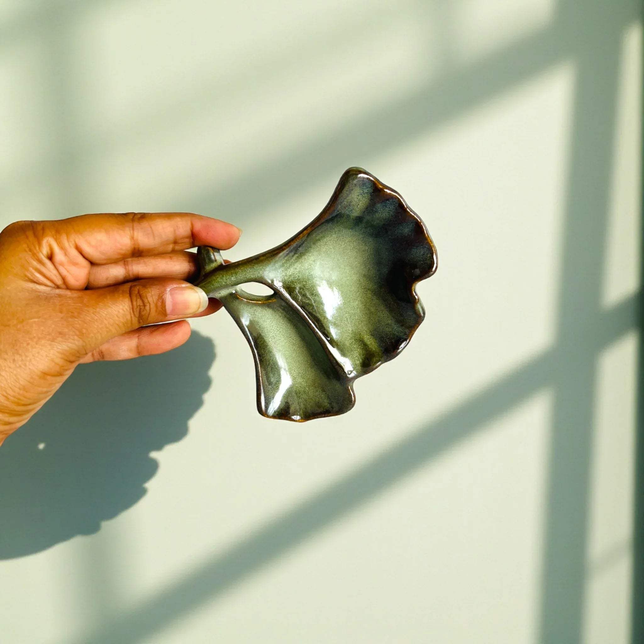 Ginkgo leaf glaze texture; handcrafted metallic gold finish and artisanal ceramic leaf detail.