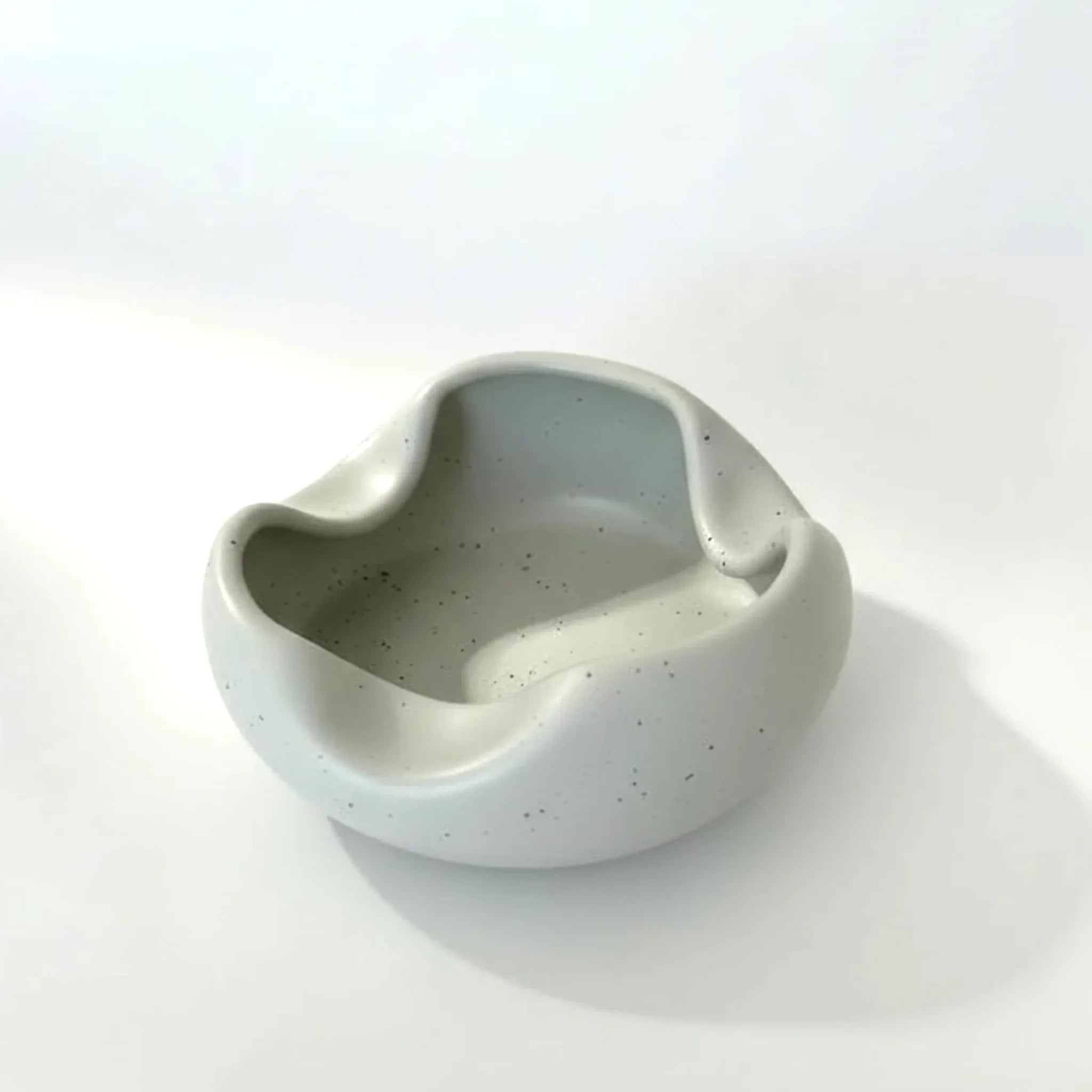 Speckled grey ceramic bowl / ashtray on a white background.