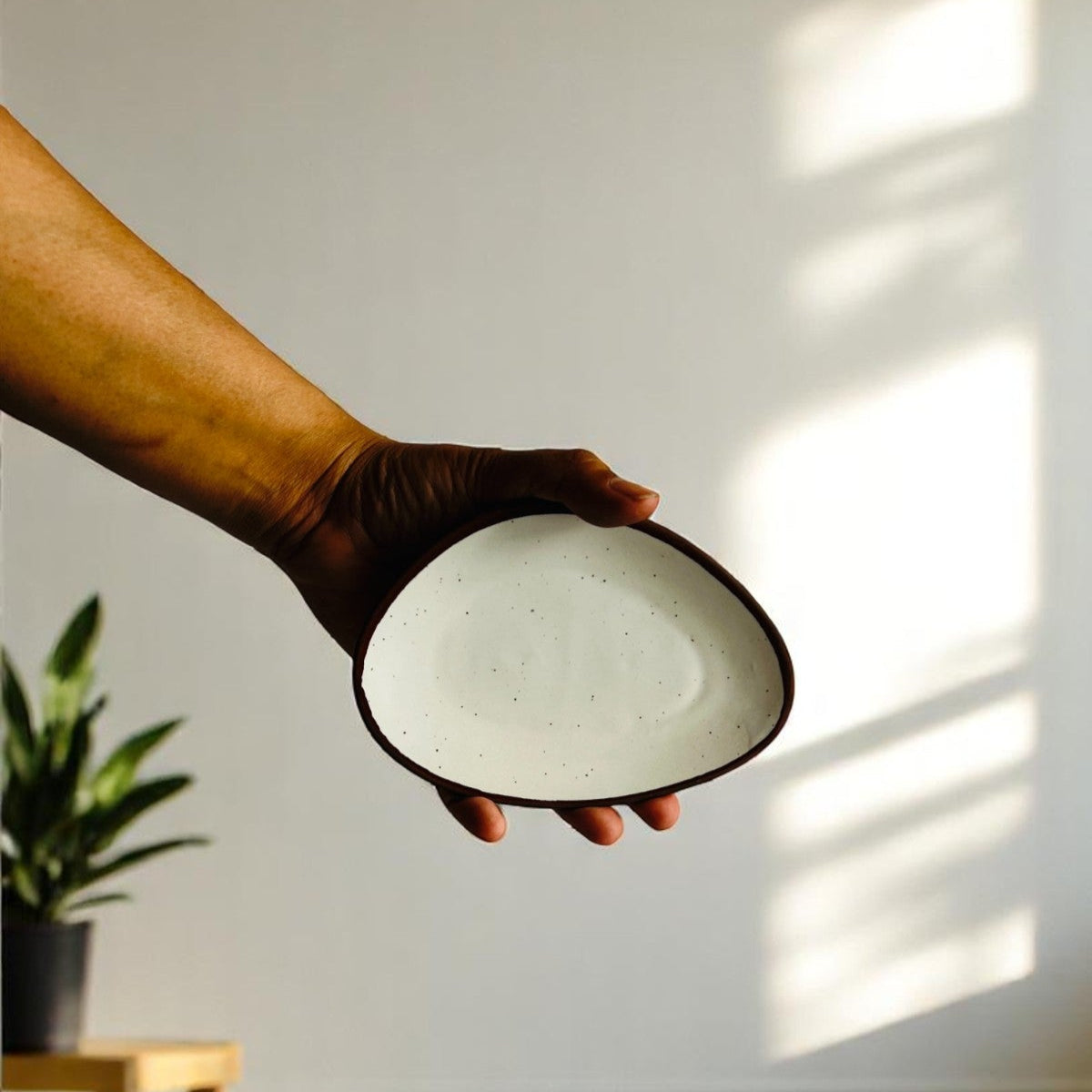 handheld artisanal ceramic saucer white saucer to show scale and size