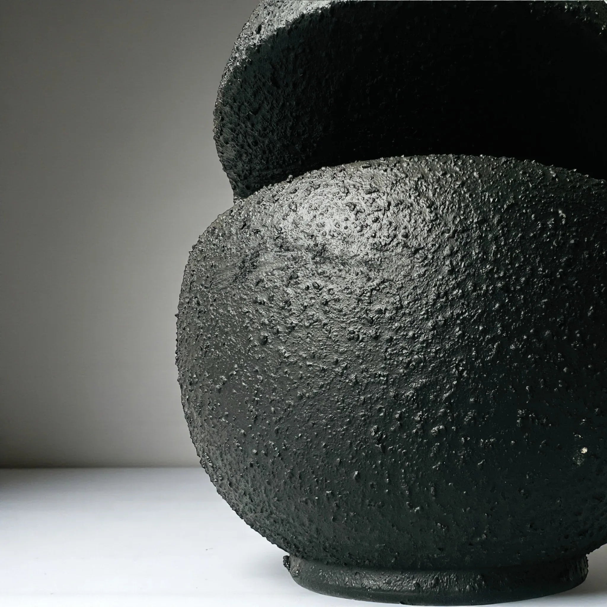 Raw inkstone texture; handcrafted matte black glaze and sculptural ceramic ridges for mood boards.