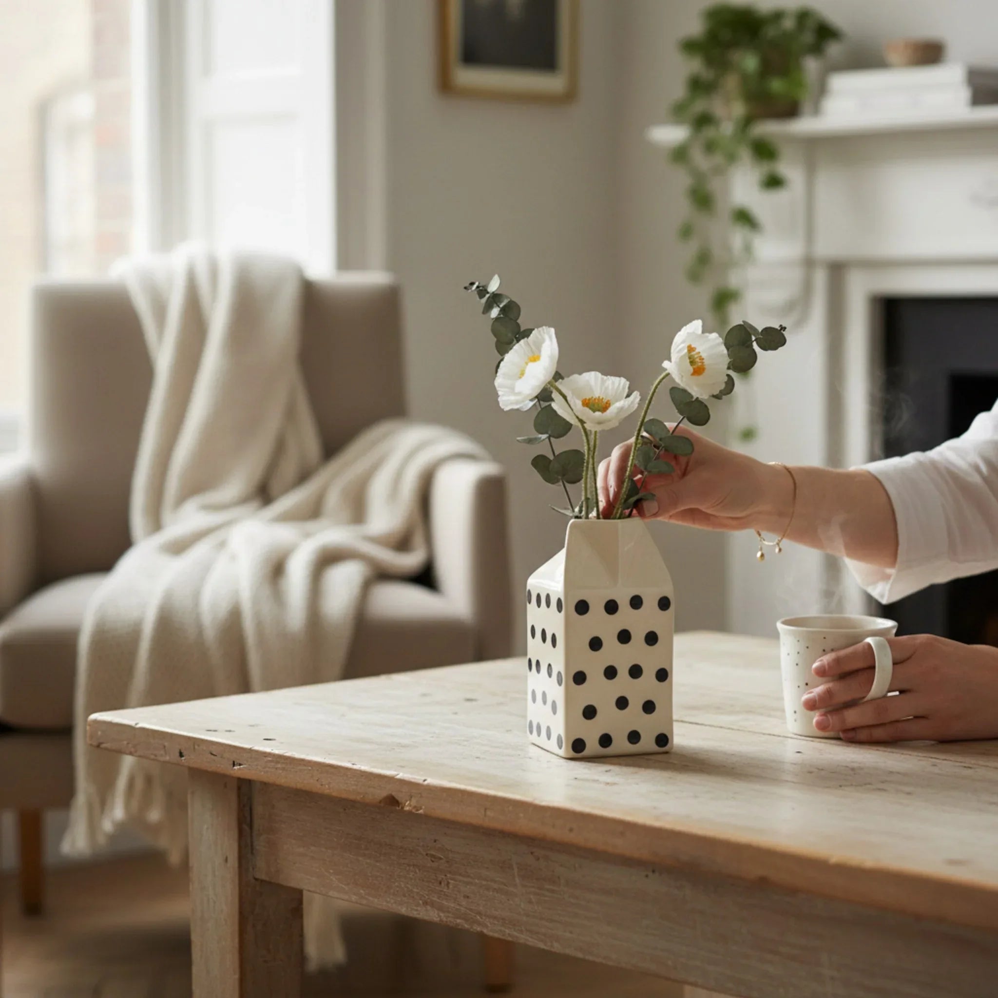 Floral decor; the Moo Jug repurposed as a petite vase holding a bunch of wild daisies on a bright table.