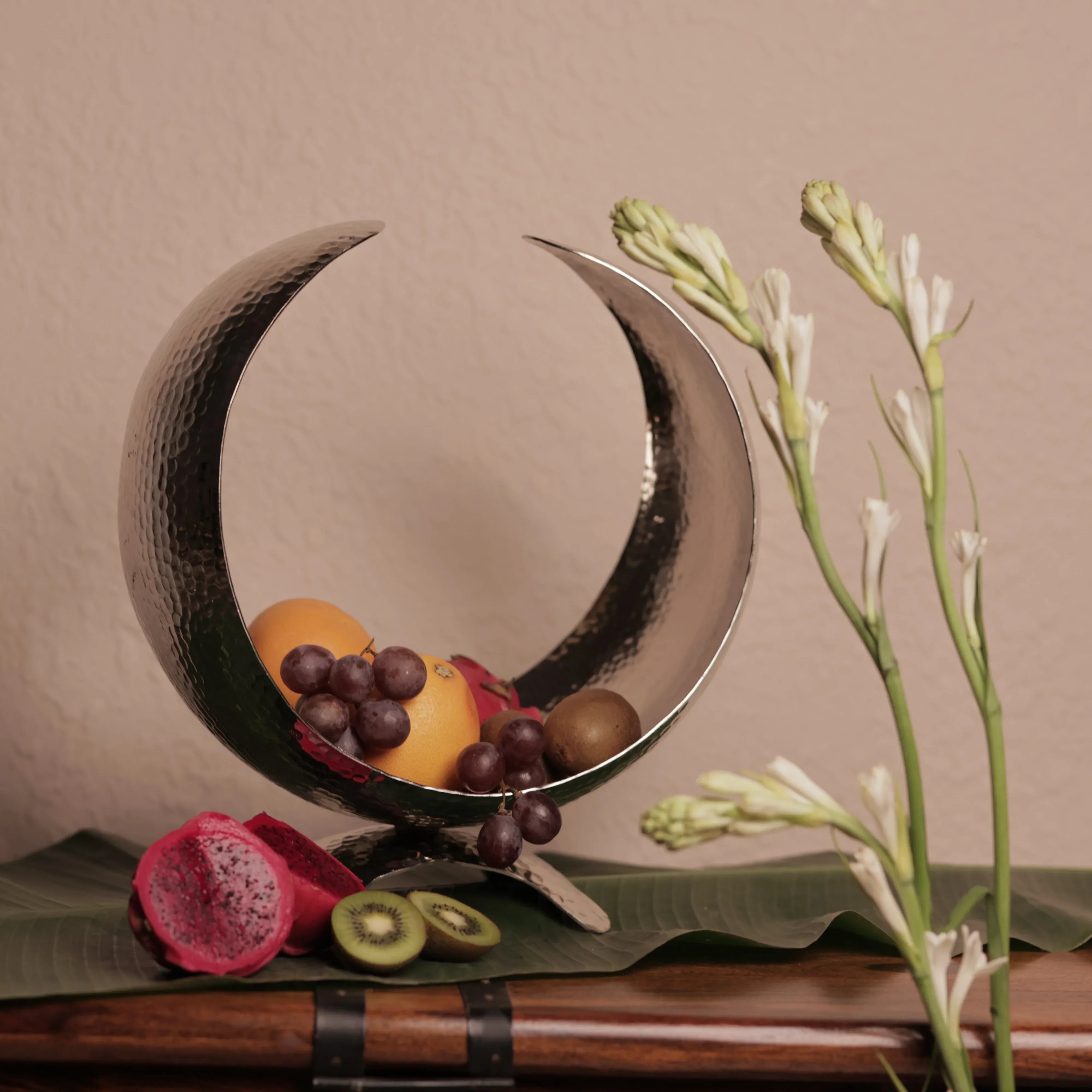 Rustic Stone Moonlit Arc Fruit Bowl; hammered silver aluminium crescent-shaped bowl with a sculptural celestial design.