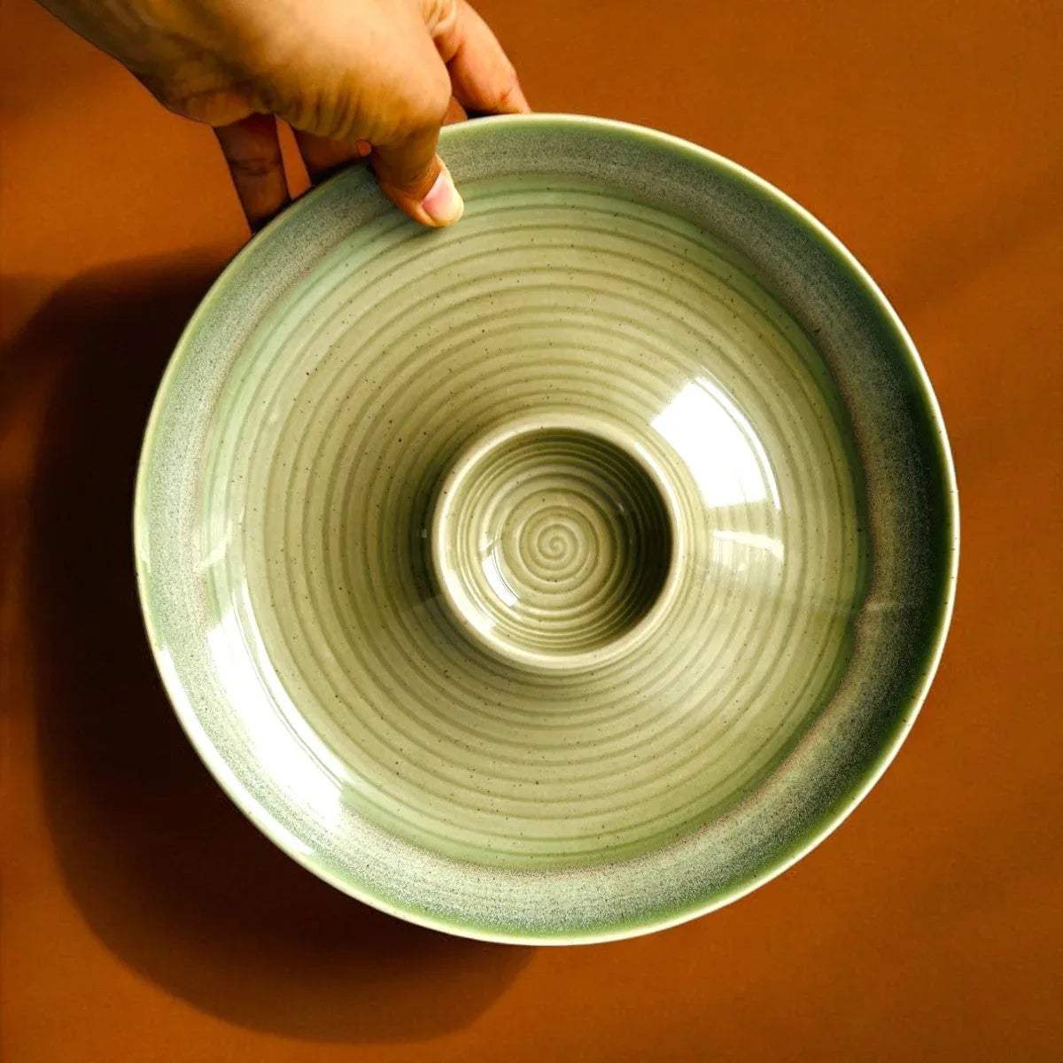 Close-up of ocean-inspired glaze; textured seafoam green ceramic finish on a snack platter.