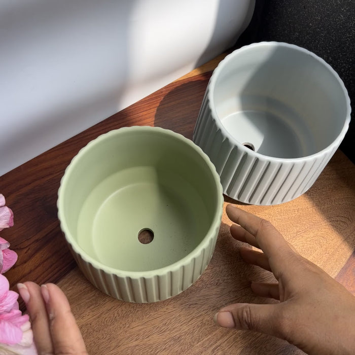 Product video of Clay Green Ribbed Planters; showing the sage green and blue-grey matte finishes, deep vertical ribbing, and drainage holes.