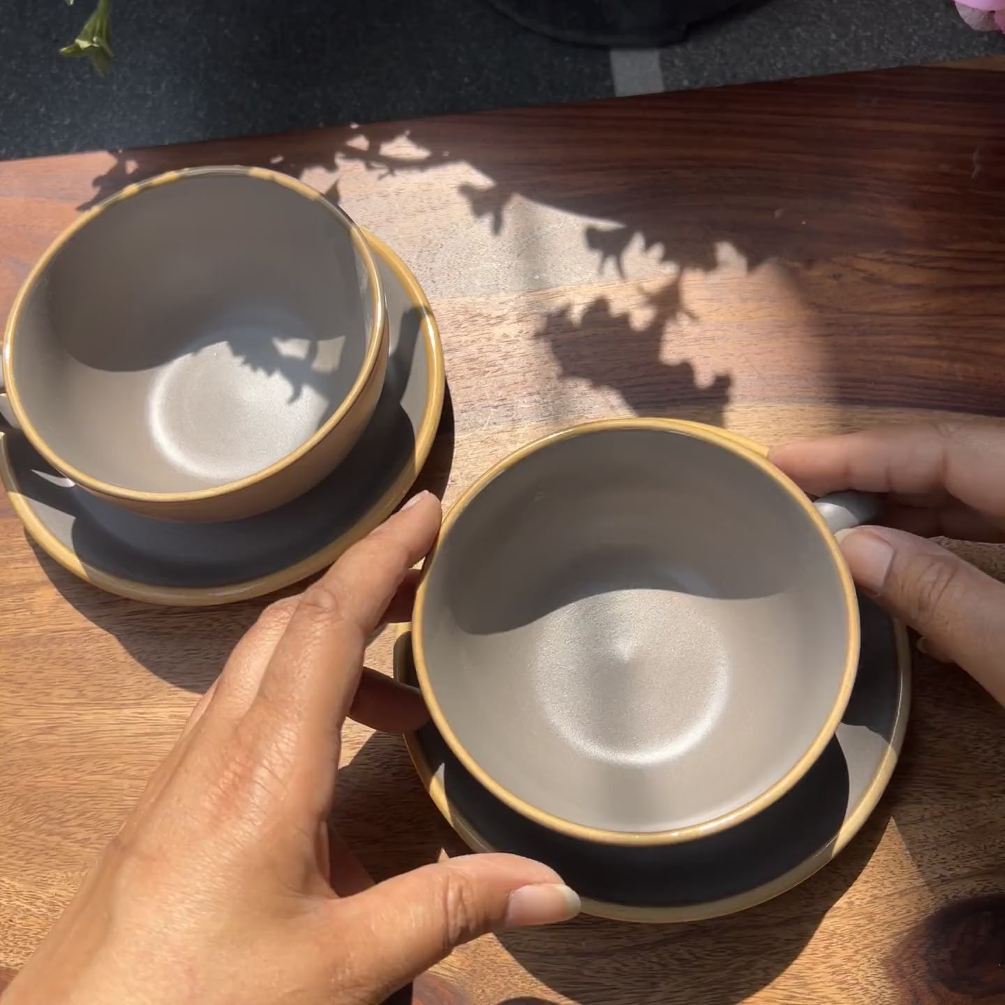 Product video of ceramic grey cup and saucer set with beige border.