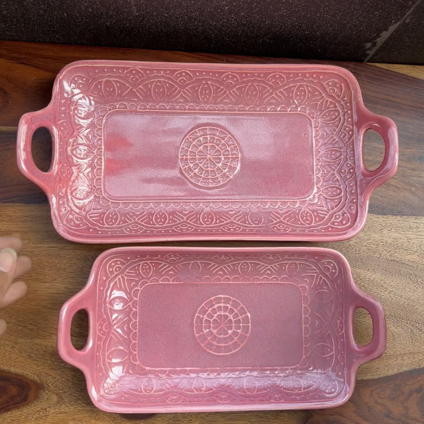 Product video of 2 pink trays with handles in ceramic. 