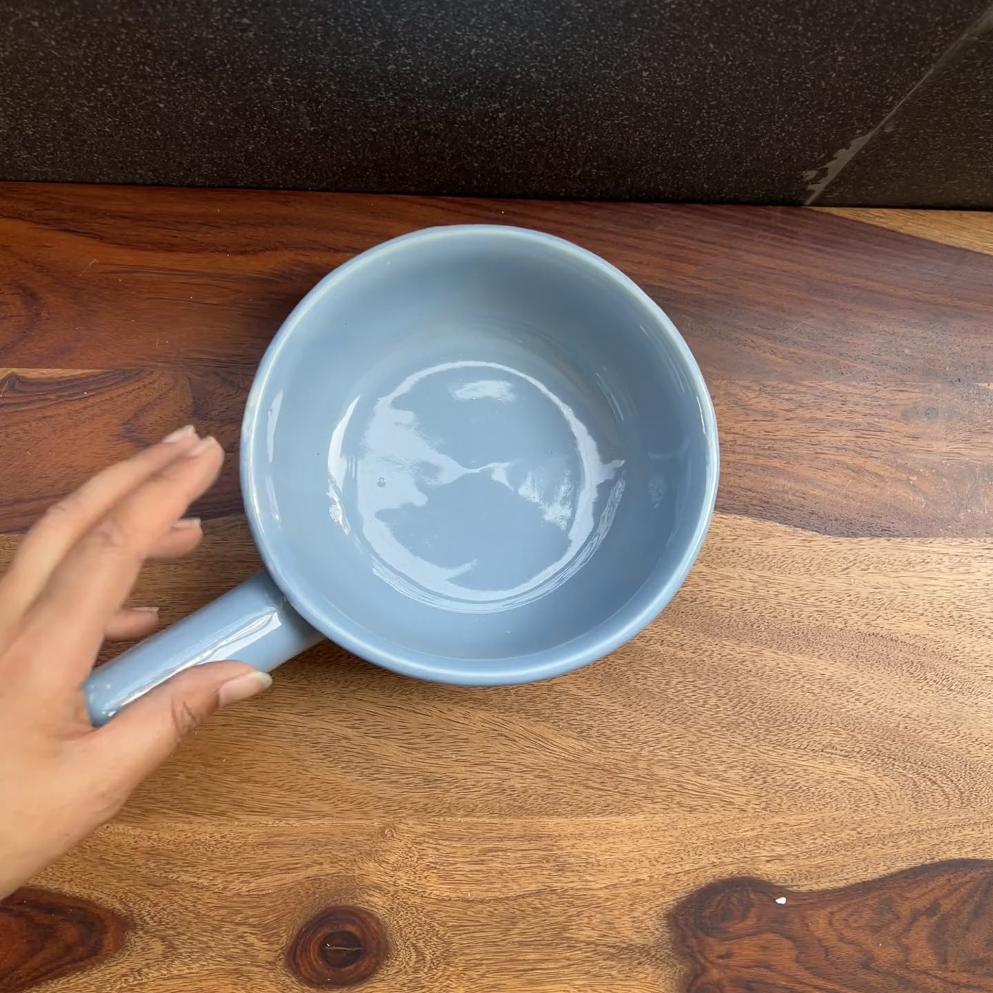 Product video of ceramic blue fondue bowl with handle.