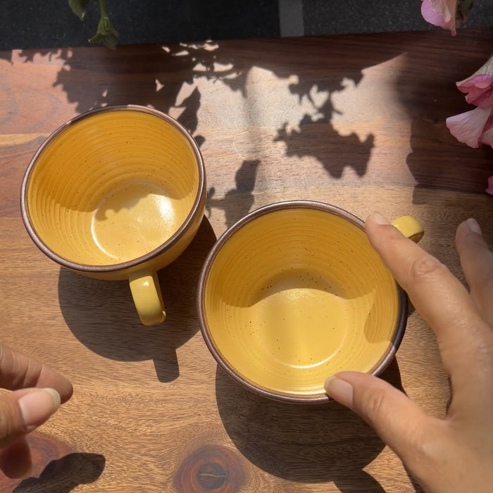 Product video of ceramic yellow cups with brown border.