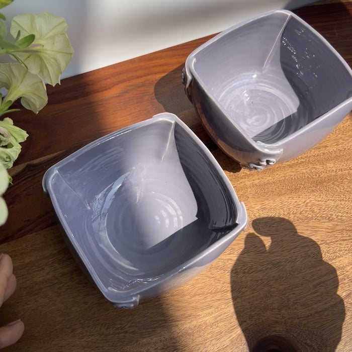 Detailed raw unedited video showing the purple glossy glaze of ceramic bowls with a button design.
