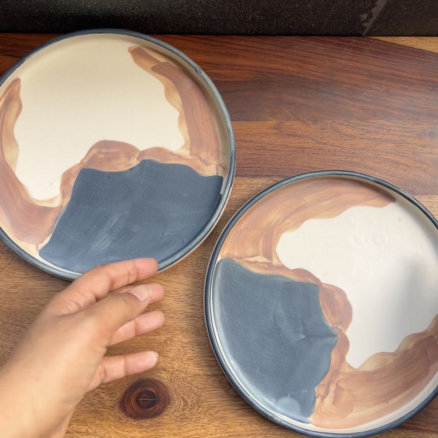 Product video of ceramic plates with desert like painting.