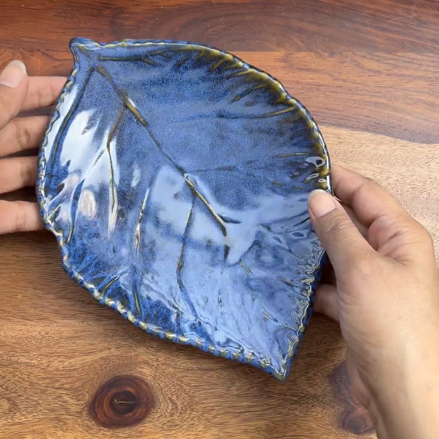 Product video of ceramic leaf in blue glaze with detailing.