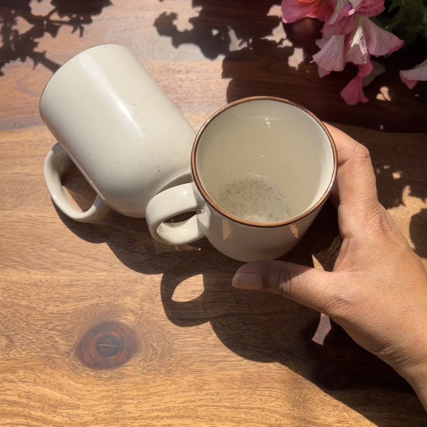 Product video of ceramic white mugs with brown border and speckles.