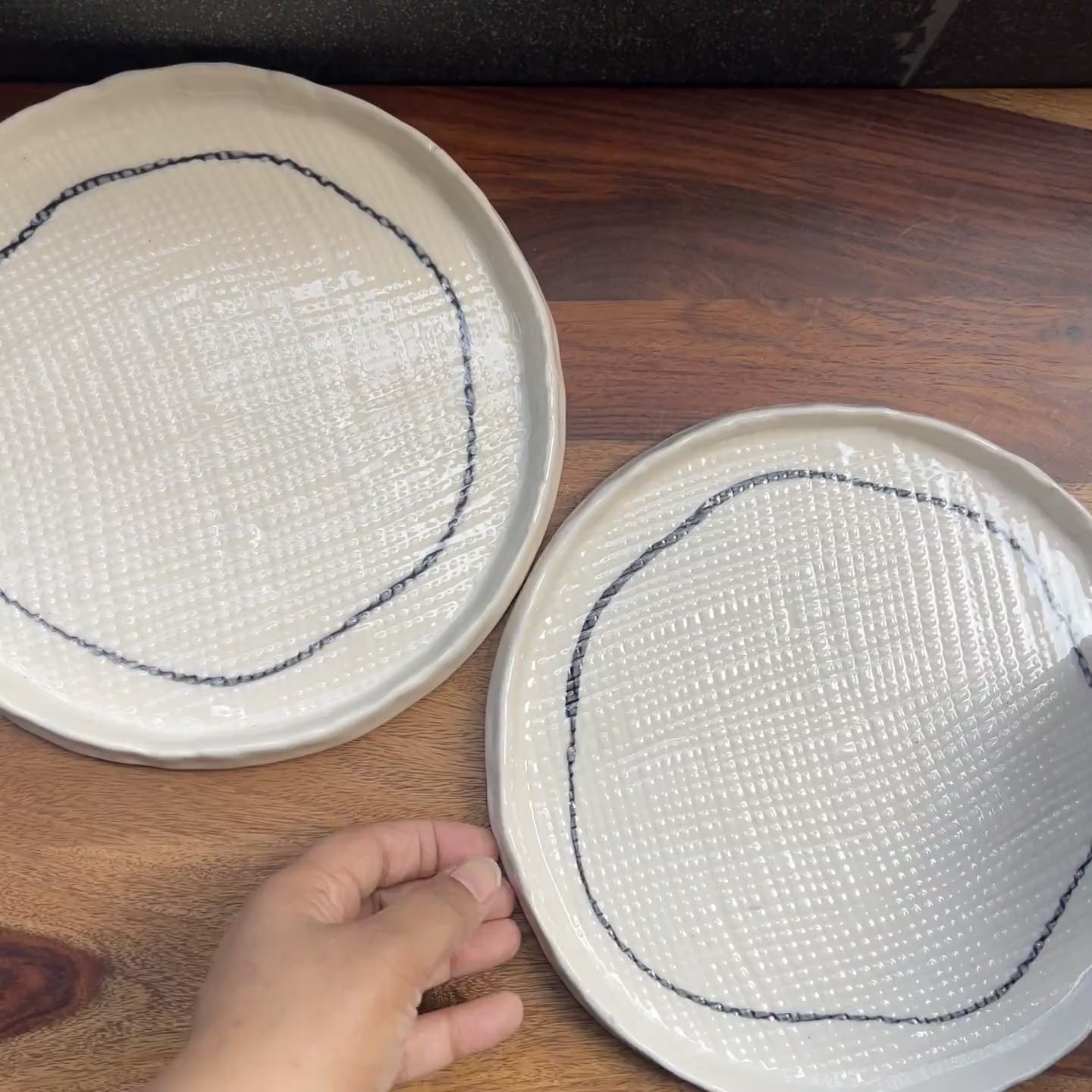 Product video of white ceramic plates with criss-cross texture.
