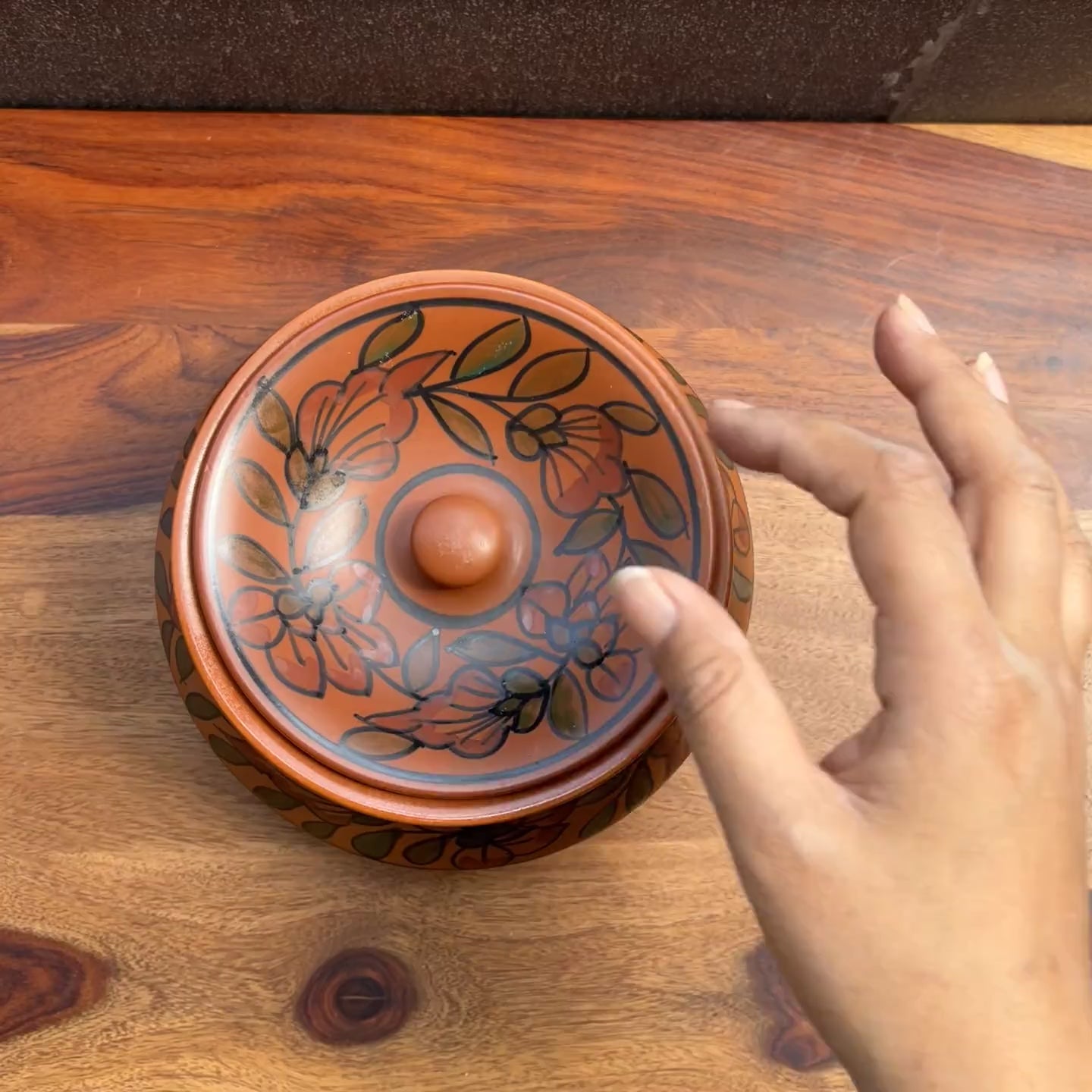 Product video of brown ceramic serving bowl with hand painted floral design.