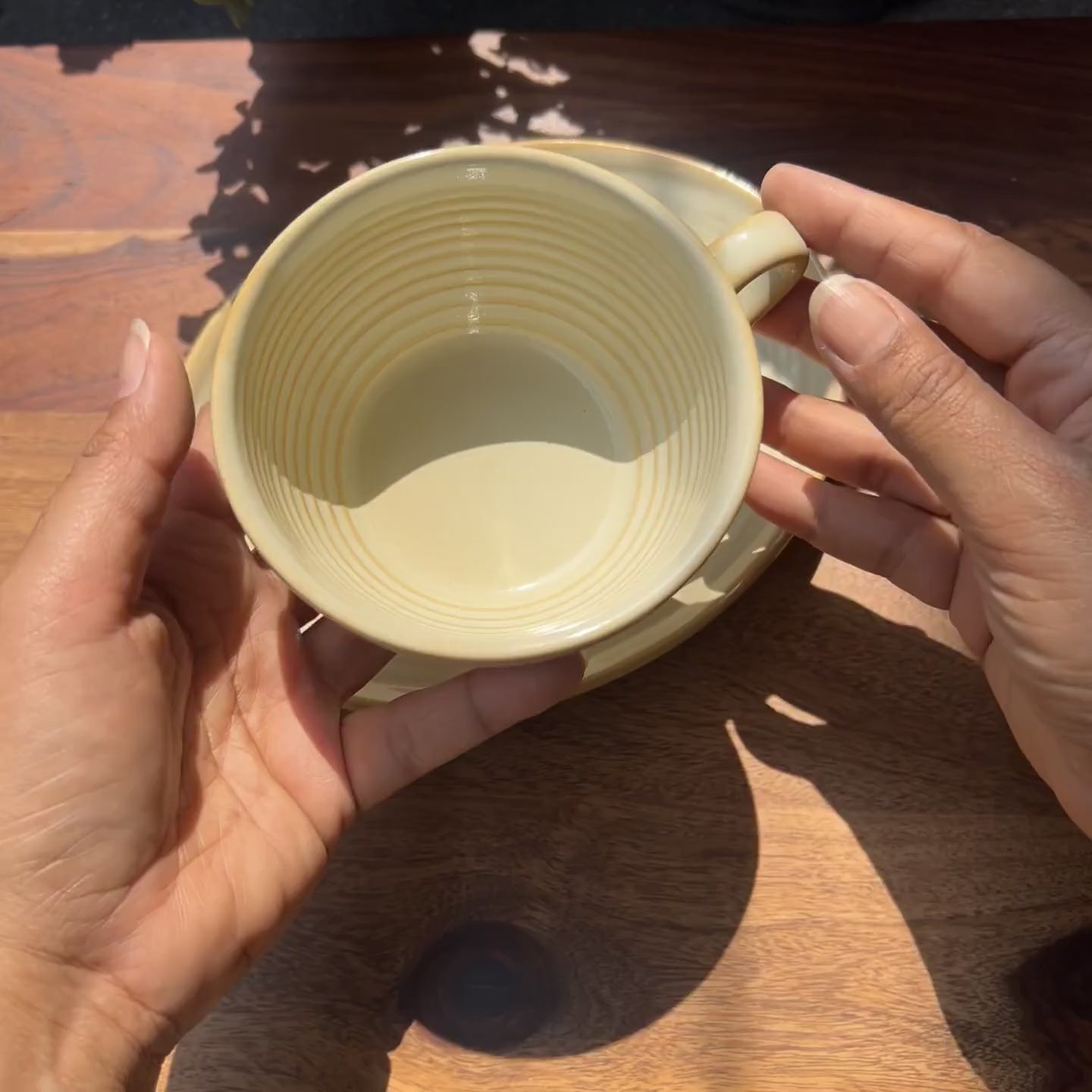 Product video of porcelain pastel yellow cup and saucer.