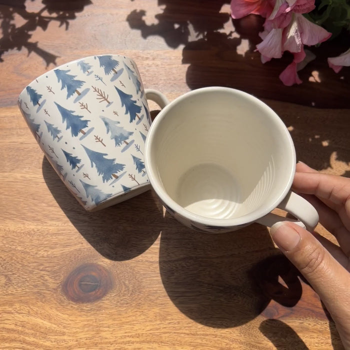 Product video of white ceramic cups with blue pine cone decal.