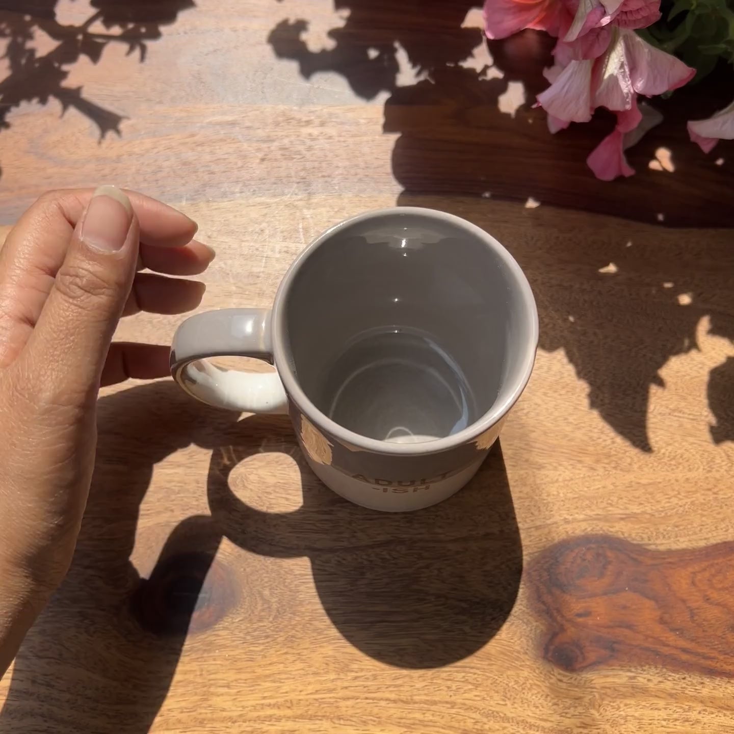 Product video of grey and white ceramic coffee mug with adultish written on it.