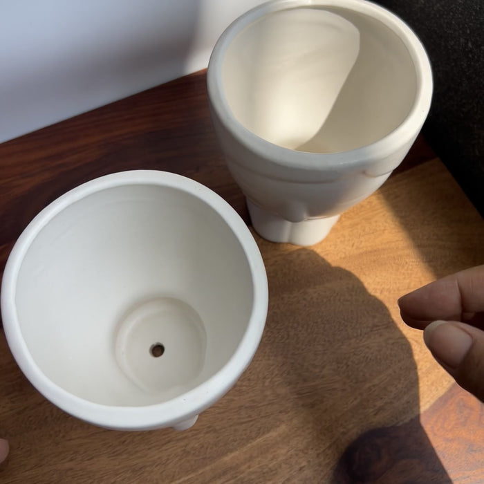 White face ceramic planters with drainage holes for healthy roots. 