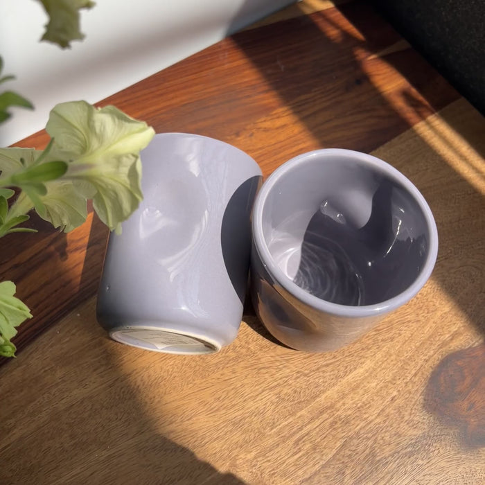 Unedited video showing the purple glossy glaze of the ceramic glasses with the maker's thumbprint.
