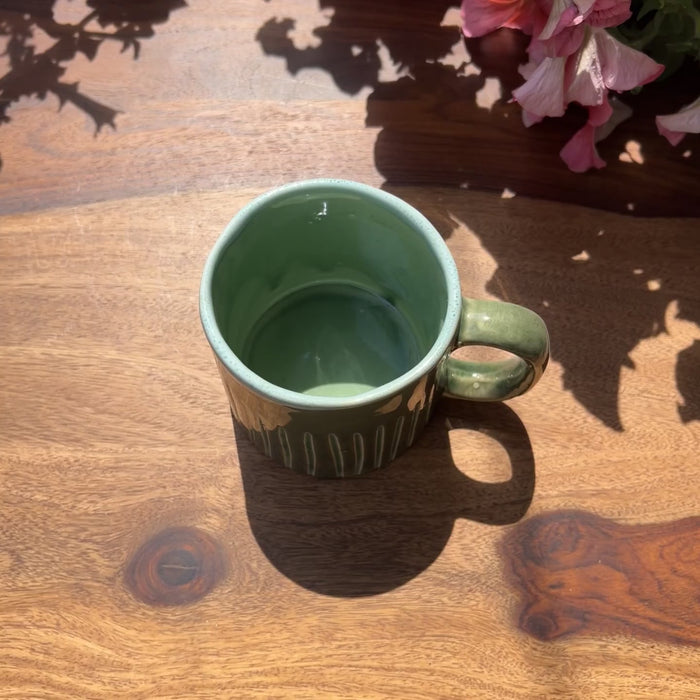 Product video of a green ceramic mug with ribbed lines.