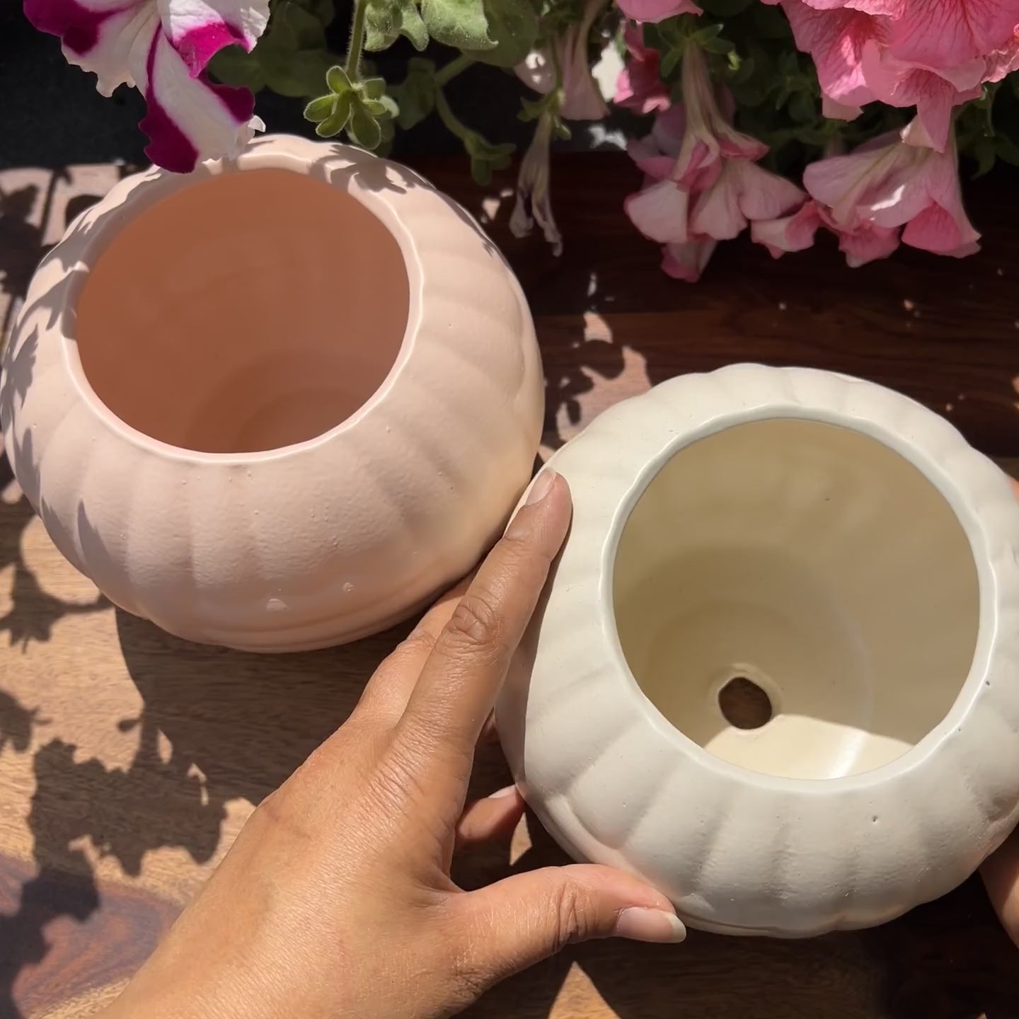 Product video of pastel pebble planters; showing the pink and white matte finish with woven texture.