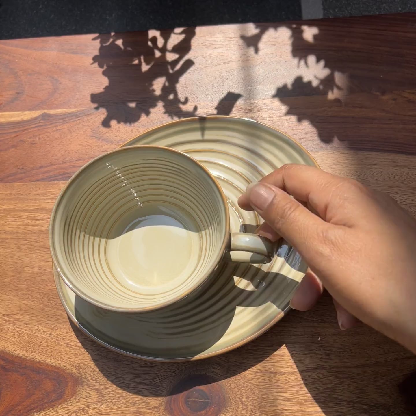 Product video of ceramic light brown cup and saucer.