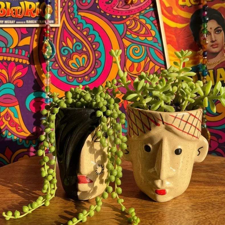 Colorful Bollywood movie posters with decorative items on a wooden surface