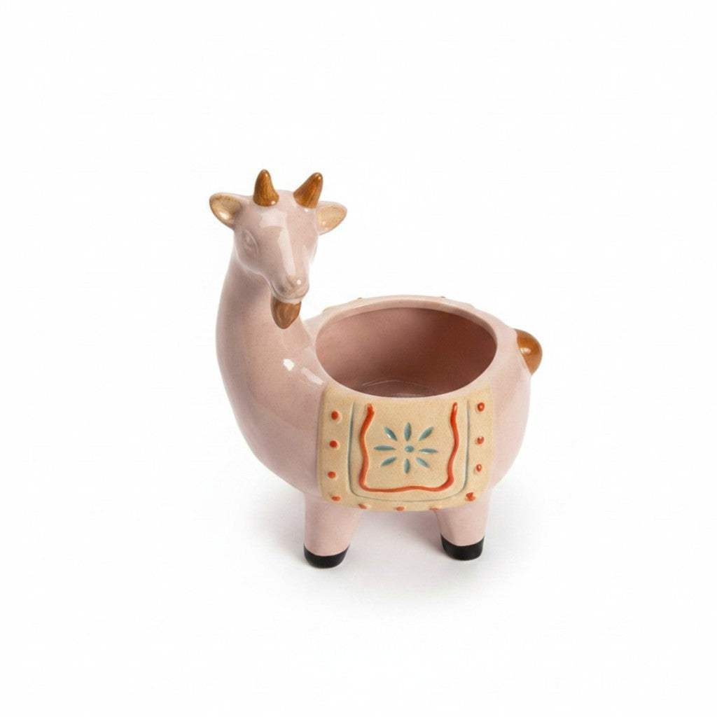 Close-up view of the detailed hand-painted saddle motif and textured high-gloss glaze finish on the pink ceramic goat pot.