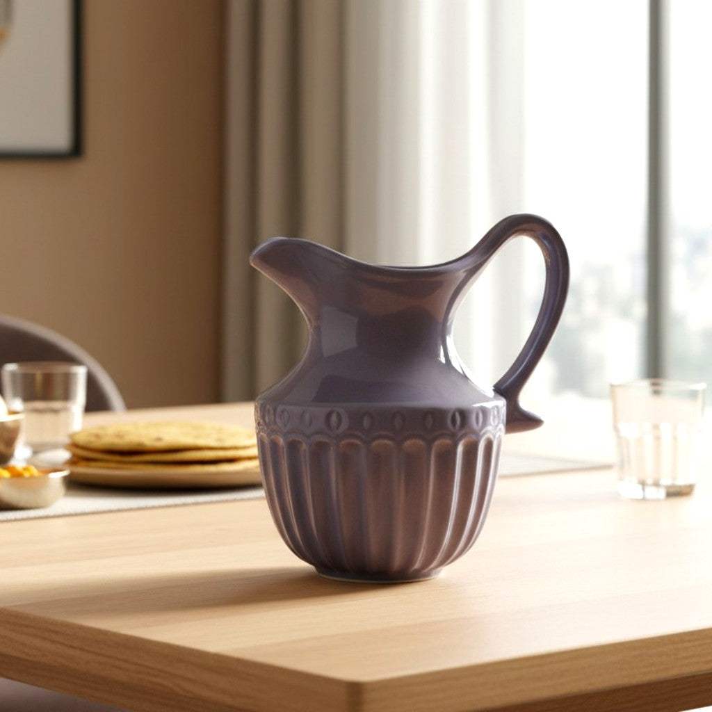 Purple ceramic pitcher on a wooden table with a blurred background