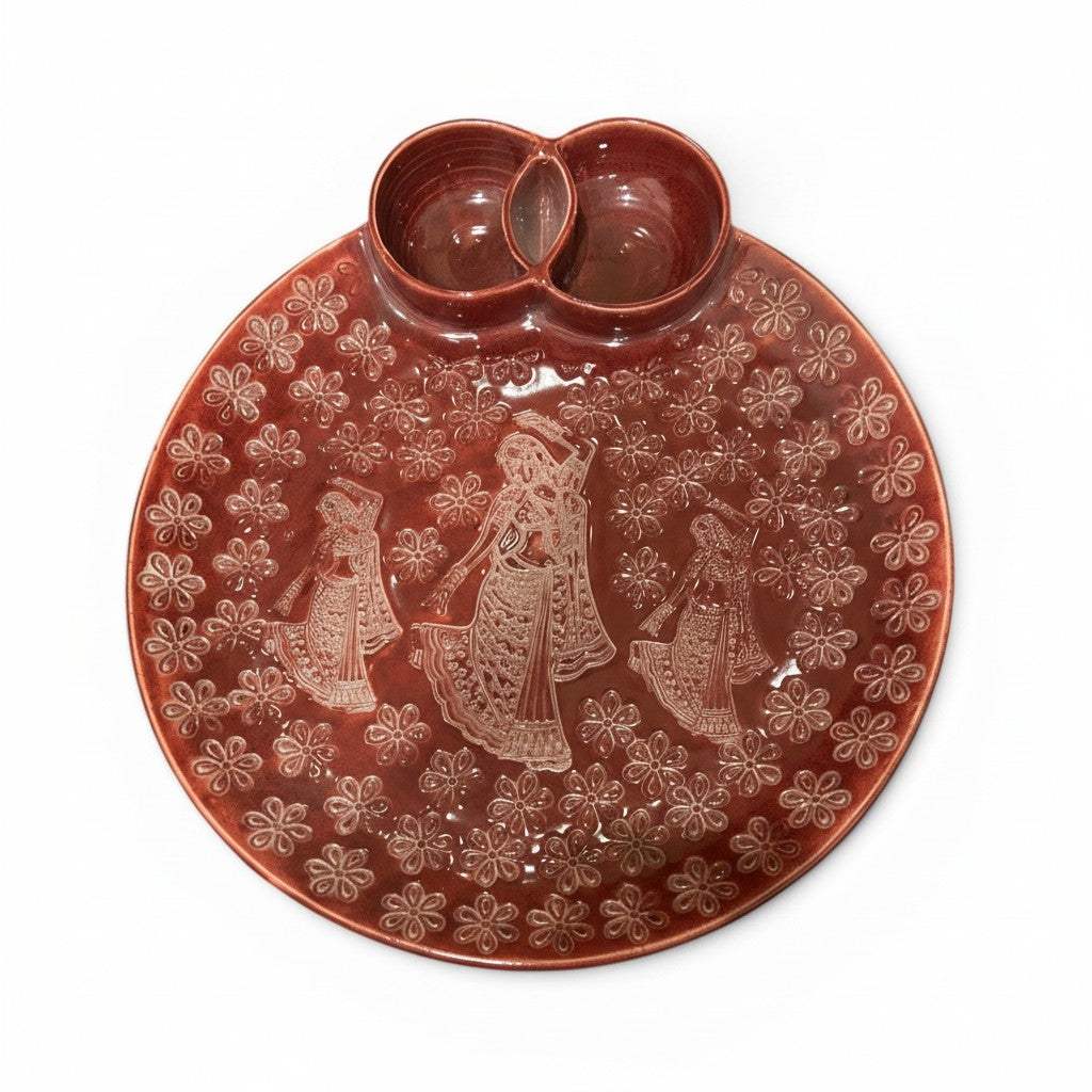 A round terracotta red ceramic chip and dip platter with hand carved folk-art motifs.