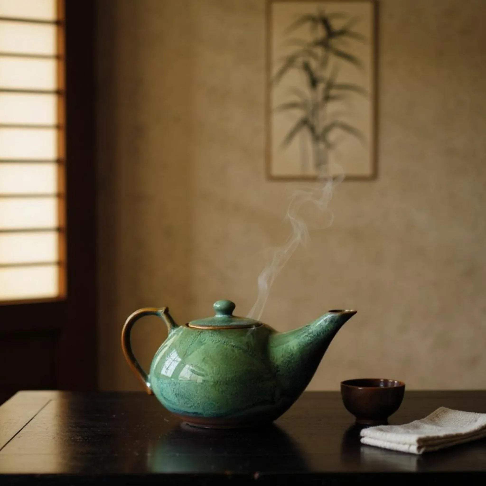 Steaming green teapot on a wooden table with a blurred background.