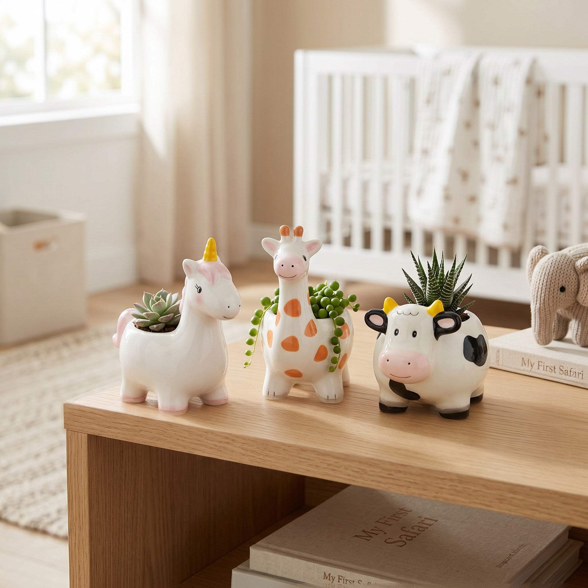 The set of three storybook animal planters displayed in front of a white baby crib.