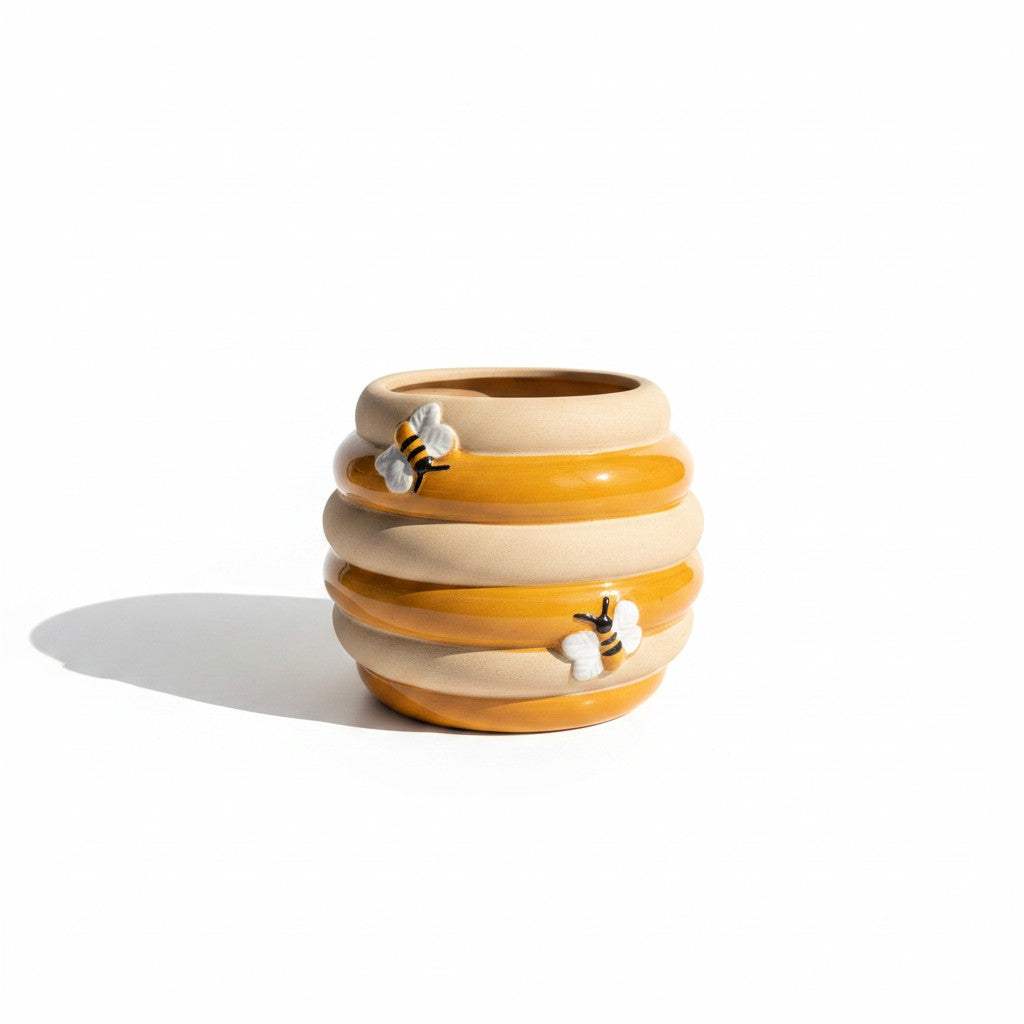 Close-up view of the detailed raised bumblebee graphics and textured matte sand bands on the yellow ceramic pot.