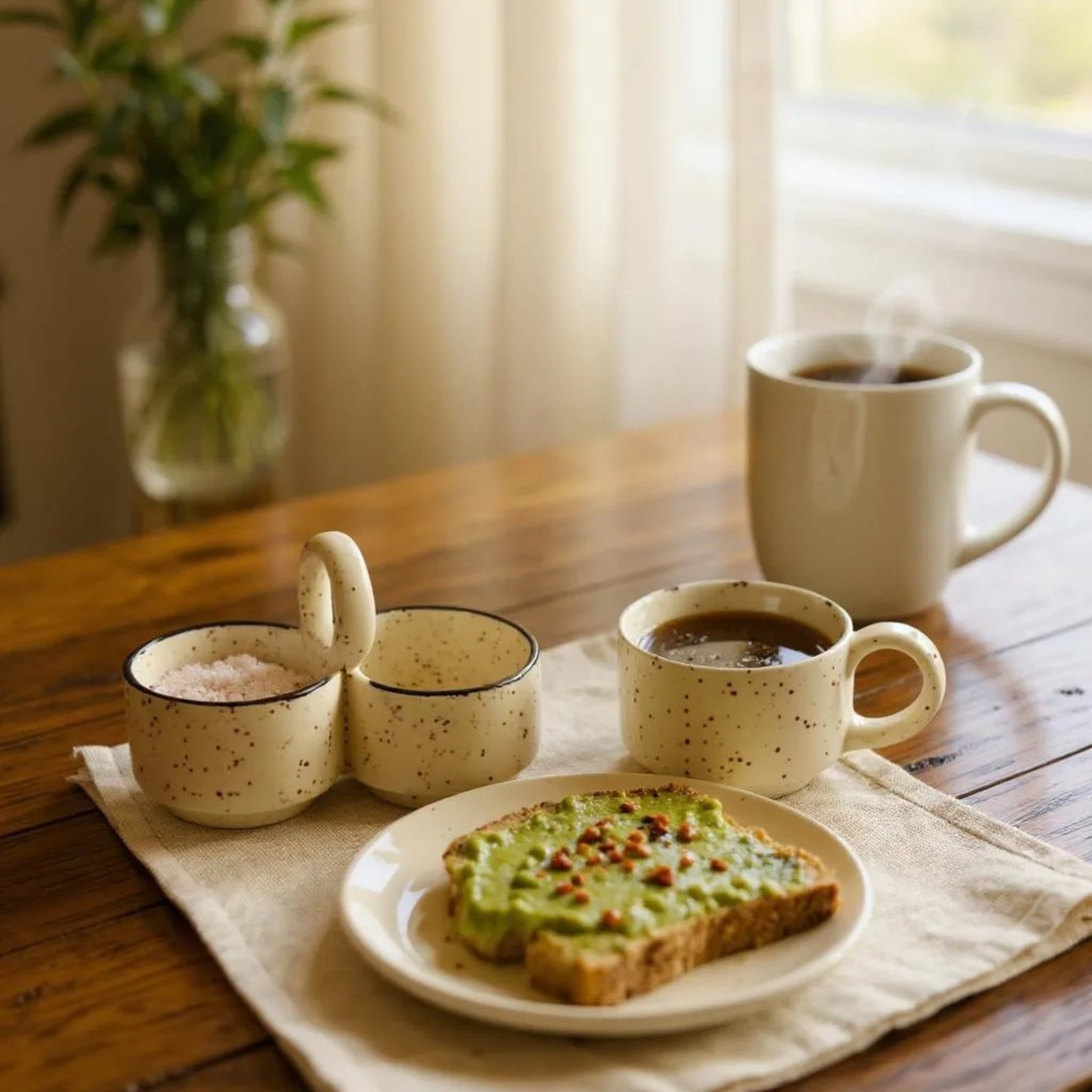 Breakfast scene with coffee, toast, and a cup on a wooden table.